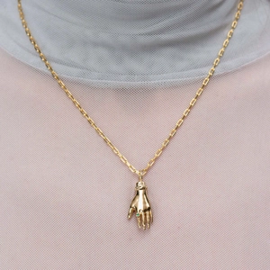Collana con ciondolo a forma di mano dorata e gemma verde dal design vintage elegante