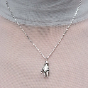 Dettaglio della collana con ciondolo a mano in argento e piccola pietra preziosa verde