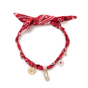Detail of red patterned fabric necklace with gold good luck and evil eye charms
