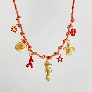 Handmade woven necklace with gold sea turtle, seahorse, and shell ocean-themed pendants