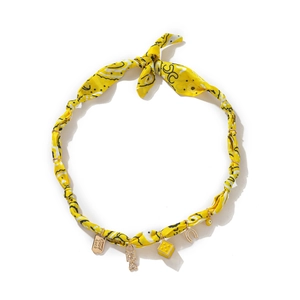 Detail of yellow silk scarf necklace with Good Luck charm, dice, and lucky horseshoe