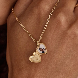 Close-up of an open heart locket necklace with a photo inside on a paperclip chain