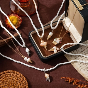 Detail of pearl necklaces with ice cream and cupcake pendants on vintage background