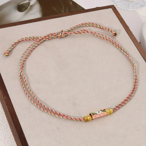 Colorful woven tarot rope bracelet with a pink enamel Evil Eye pendant and gold beads