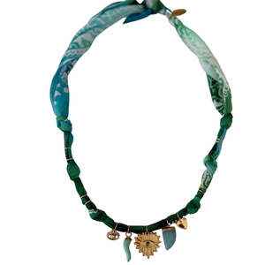Detail of bohemian fabric ribbon necklace with gold heart Hamsa and turquoise charms
