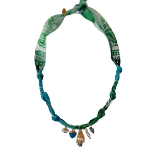 Detail view of leopard print cord necklace featuring starfish, shell and evil eye charms