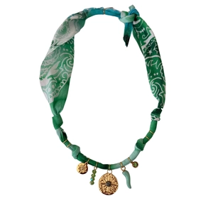 Detail of bohemian fabric necklace featuring starfish pendants and green paisley textile texture
