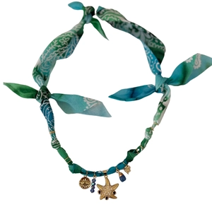Detailed close-up of Bohemian leopard print fabric necklace with starfish and sun pendants
