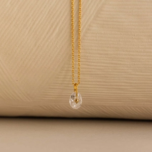 Detail van de Noordster ovale kristallen hanger aan een goudkleurige ketting