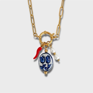 Détail du collier chaîne trombone doré avec piment rouge, perle céramique et pendentifs