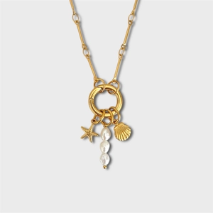 Détails macro de pendentifs étoile de mer, coquillage et perles sur un collier doré marin