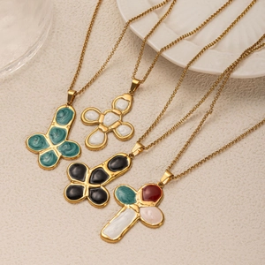 Detail view of colorful pebble-style cross pendants on gold plated titanium necklaces