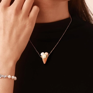 Dettaglio della collana con pendente a gelato di perle su modella con trama oro rosa