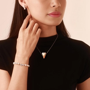 Dettaglio del set collana e orecchini di perle con ciondoli a cono gelato dorato