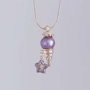 Dettaglio di una collana con ciondolo a gelato, perla viola e cono placcato oro