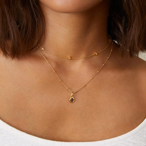 Close-up of 18K gold-plated double-layer necklace with stars and purple birthstone