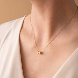 Gold titanium birthstone necklace featuring a cylindrical zircon charm on a minimalist chain