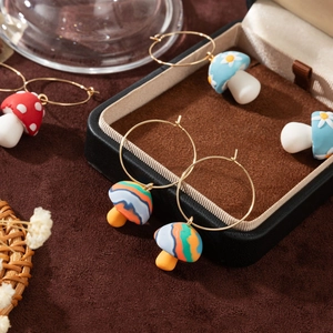 Handmade colorful mushroom hoop earrings with vintage drip oil design on a brown background