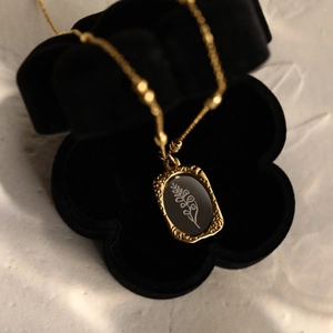 Vintage French 18K gold floral necklace with black enamel pendant in a flower jewelry box