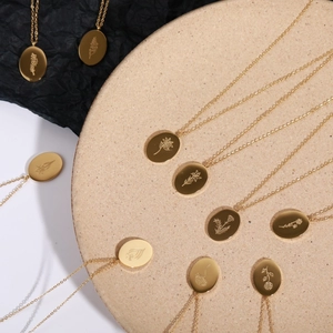 Golden stainless steel oval birth flower necklaces with detailed floral engravings for women