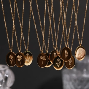 Series of golden oval stainless steel floral necklaces with diverse flower engravings