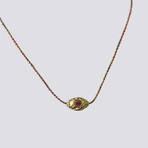 Detail of handmade Nepalese ethnic necklace with pink gemstone and tricolor braided cord