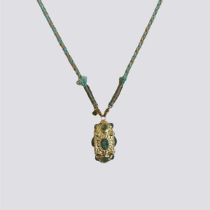 Detailed close-up of a retro Nepalese necklace with gold metal and green gemstones