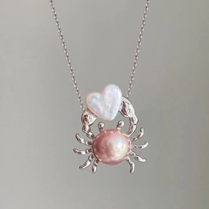 Détail du collier crabe en or 18 carats avec perles irisées en forme de coeur