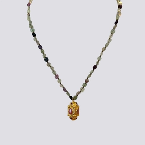 Detail of vintage copper necklace with red gemstones and colorful mineral beads