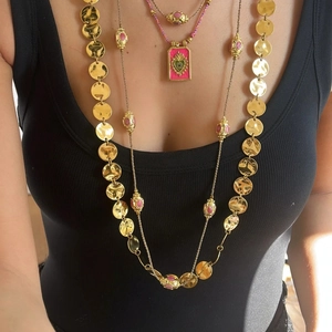 Ethnic bohemian layered necklace set with gold hammered discs and pink charms on black vest