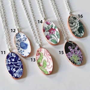 Detailoverzicht van vintage ovale bloemenhangers met goud vergulde kettingen