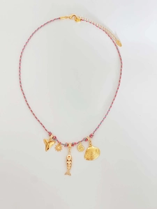 Detail of colorful braided cord necklace with gold marine charms like sun and seashells