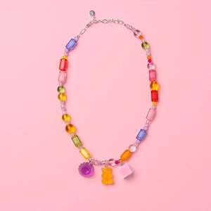 Colorful beaded Y2K necklace with gummy bear and flower pendants on pink background