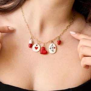Detalle del collar bañado en oro de 18K con fresa esmaltada y colgantes de corazón