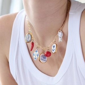 Detalle de collar de oro de 18K con siete colgantes coloridos de cerámica y diseño de amor