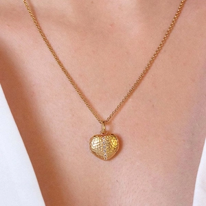 Détail d'un collier pendentif cœur en or martelé avec une rangée verticale de zircons