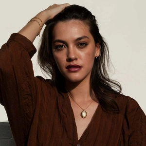 Parure de colliers plaqués or 18k avec médaillon ovale portés sur une chemise en soie