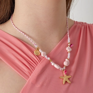 Collier pendentif étoile de mer et coquillage avec corde rose sur mannequin