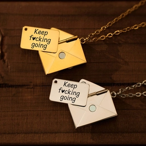 Detail van creatieve envelopketting met gegraveerde Keep f♥cking going metalen kaart