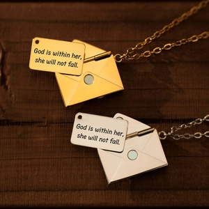 Macro detail van de envelop hanger ketting met gegraveerde inspirerende metalen inzet
