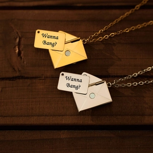Detailopname van de gouden en zilveren envelop hangers met gegraveerde metalen inzetstukken