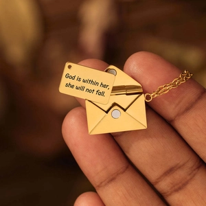 Gedetailleerd beeld van gouden enveloppe ketting met een uitneembare gegraveerde metalen kaart