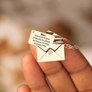 Detailopname van een gouden envelophanger met een gegraveerde binnenste kaart