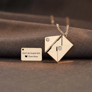 Macro-opname van de envelopketting van titaniumstaal met gegraveerd plaatje van mama