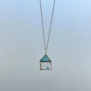 Detailaufnahme eines blauen Hausanhängers mit Emaille-Mushroom-Design an einer Silberkette