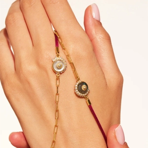 Detalle de pulseras doradas con nácar, labradorita y colgantes de sol elegantes
