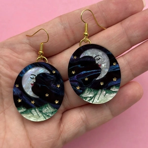 Hand holding vintage celestial moon and star earrings with gold-plated hooks