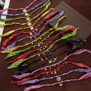 Close-up of bohemian silk scarf necklaces with colorful paisley prints and metal charms
