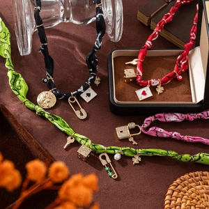 Detail of colorful silk wrap necklaces with bohemian alloy charms on vintage background