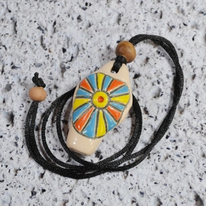 Handmade ceramic flower whistle necklace with colorful sun patterns and black cord